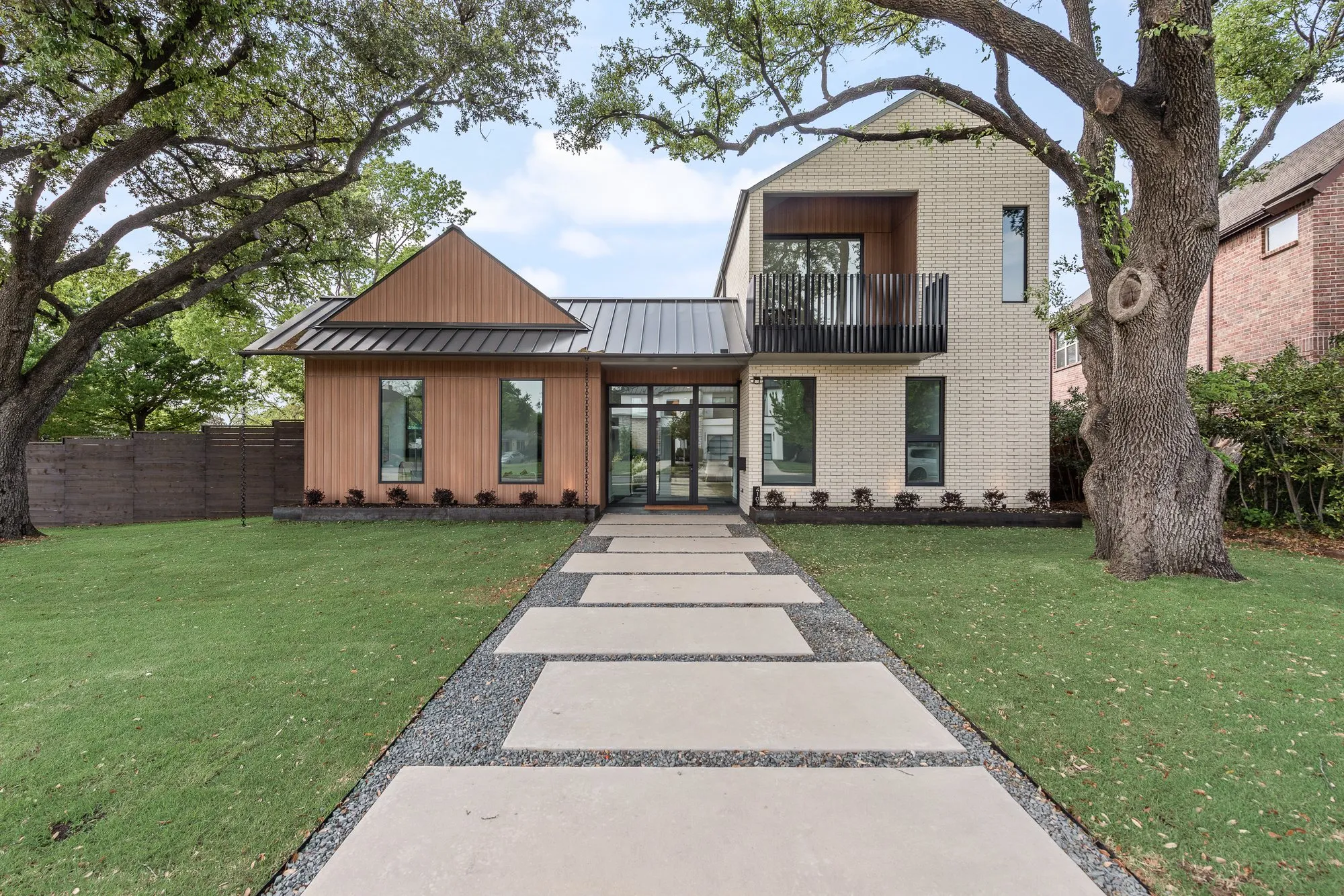 4103 Saranac: front of the house in daylight, with a paved walk between two oaks