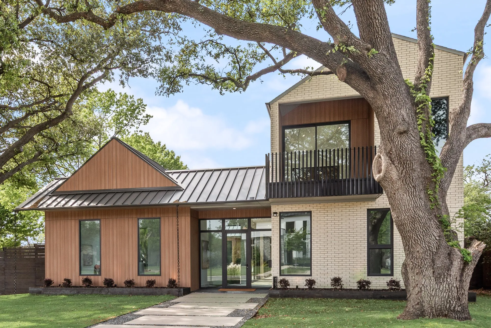Front of the house in daylight, behind a large oak