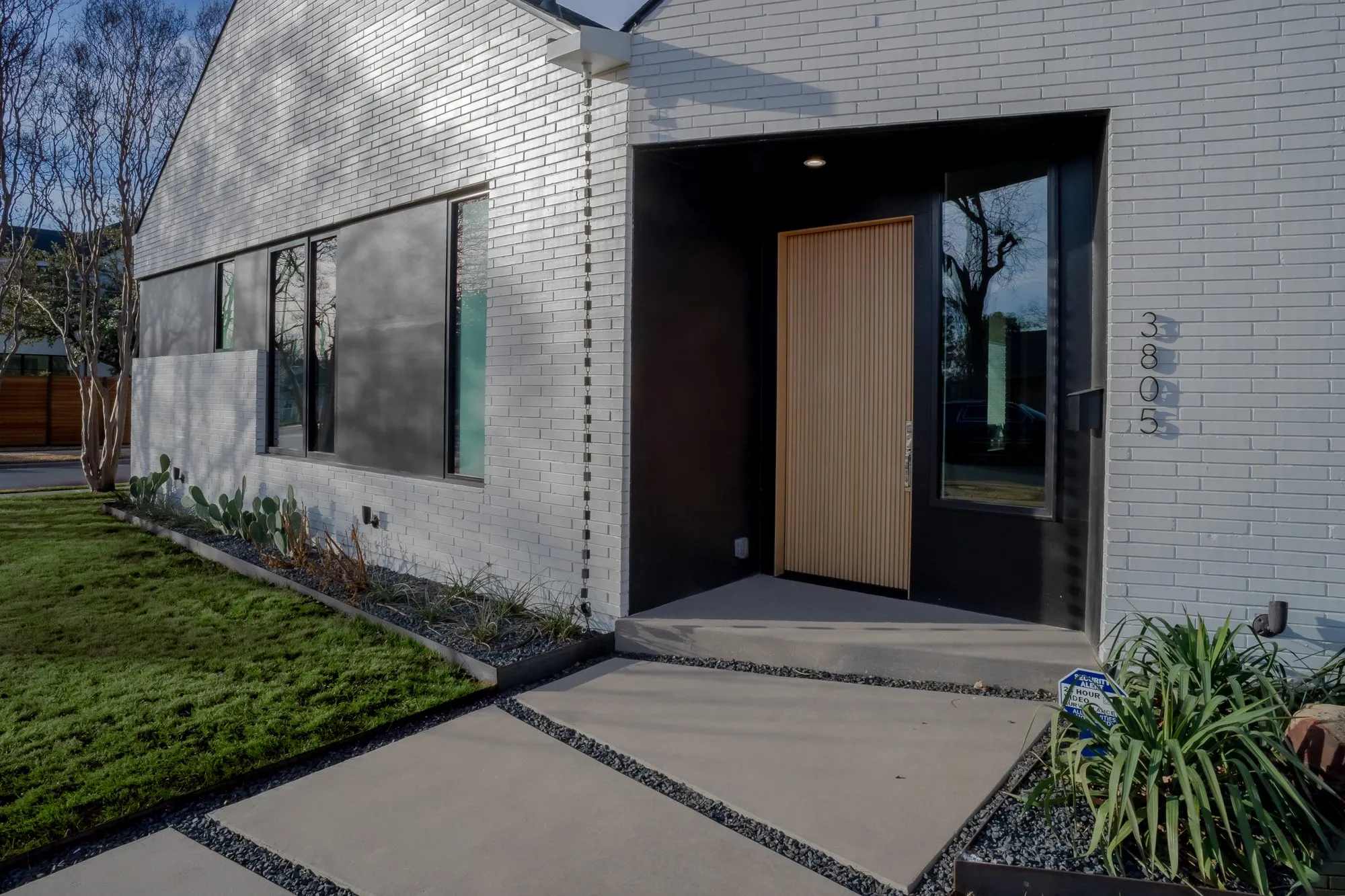 3805 Eaton Drive: entry with a wood front door beside white brick