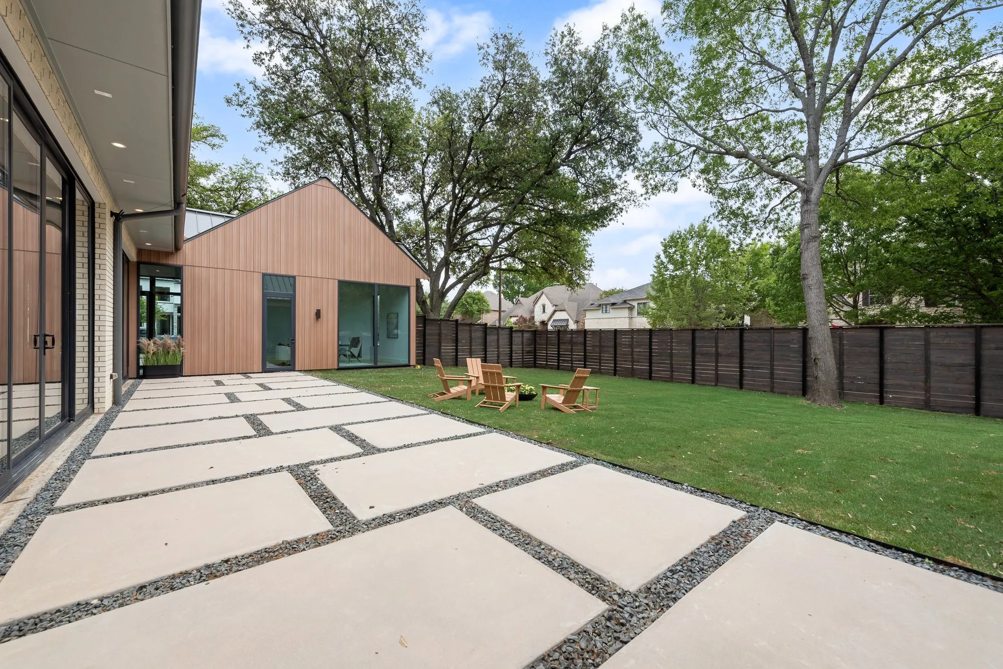 4103 Saranac: paved terrace and lawn behind the house, with chairs around a fire bowl