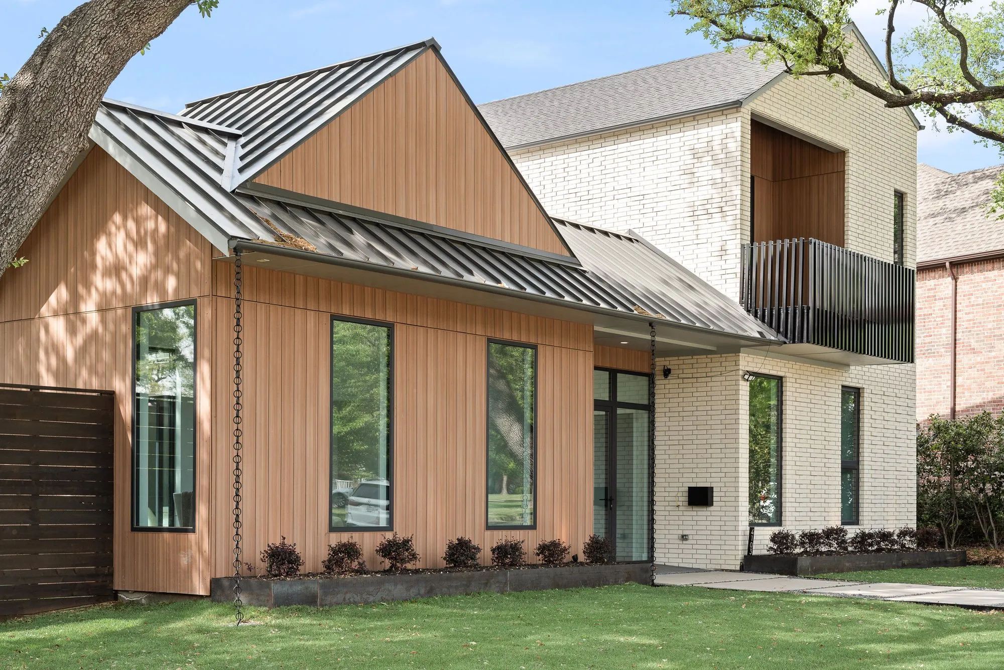 Wood-clad gable and metal roof beside the brick upper floor