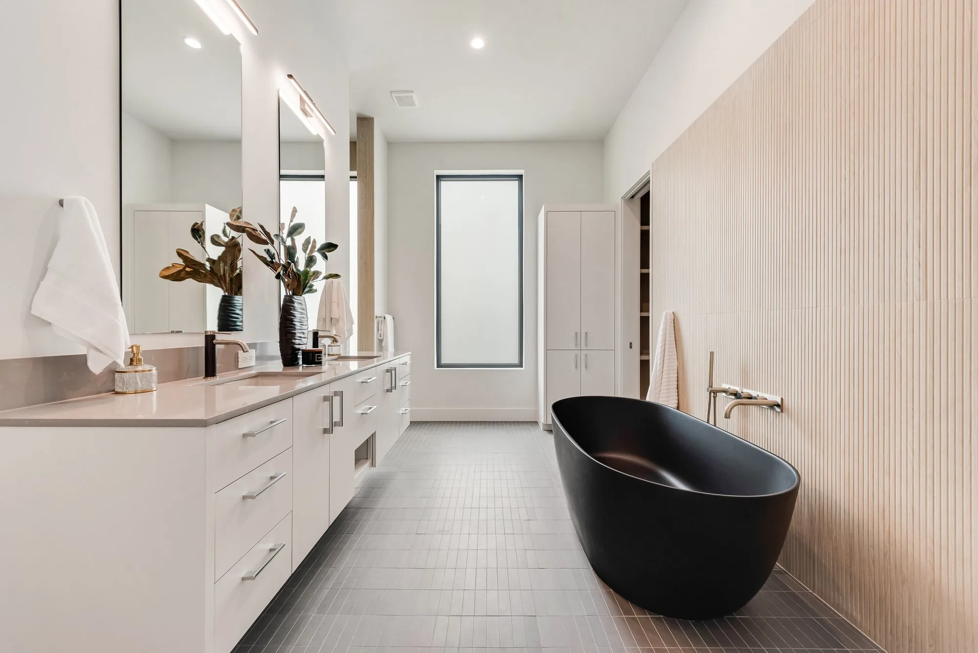4103 Saranac: bath with a long white vanity and a black freestanding tub
