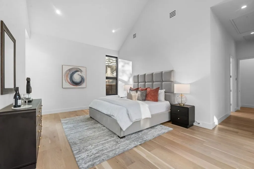 Bedroom with a vaulted ceiling and wood floors