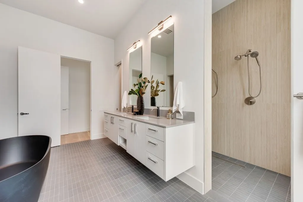 Bath vanity with two mirrors beside a walk-in shower