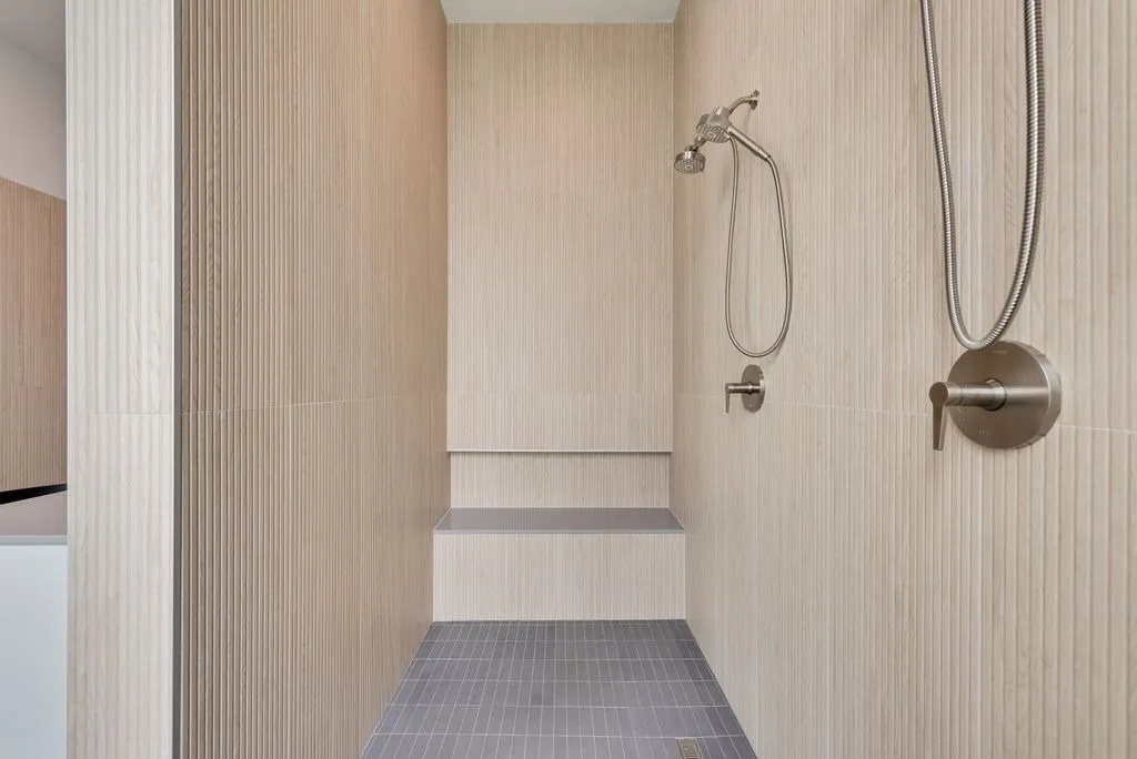Walk-in shower with a bench and fluted tile