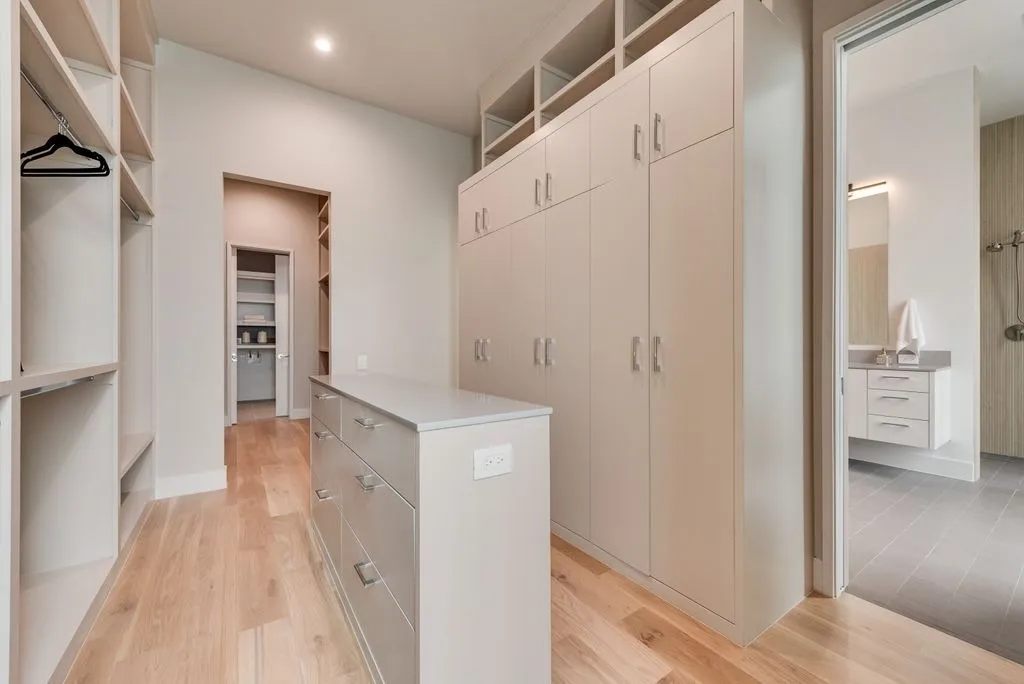 Dressing room with built-in cabinets and an island of drawers