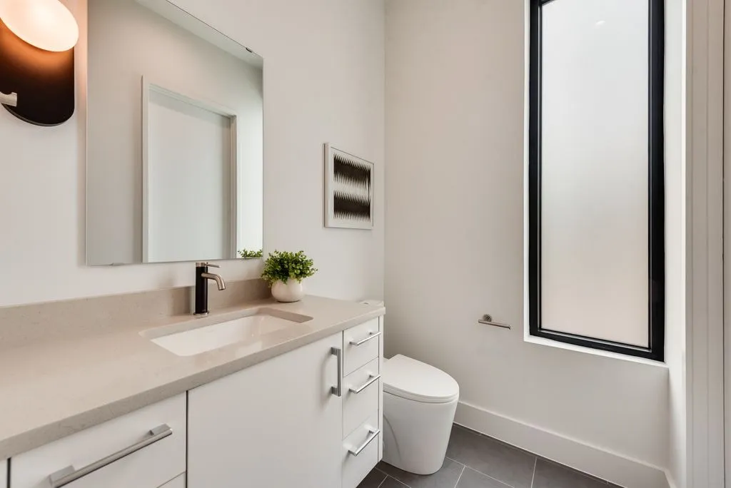 Bath with a white vanity and a tall frosted window