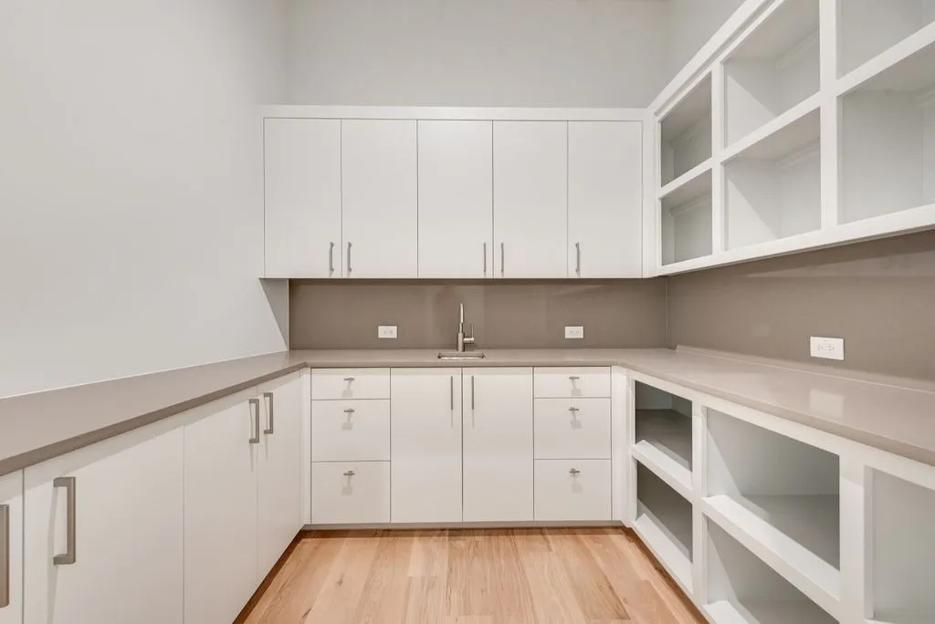White cabinets, open shelves and a counter with a sink