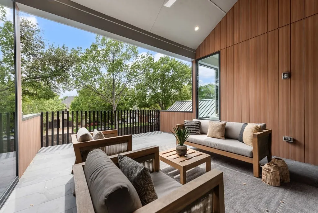Covered balcony with wood-clad walls and a metal railing