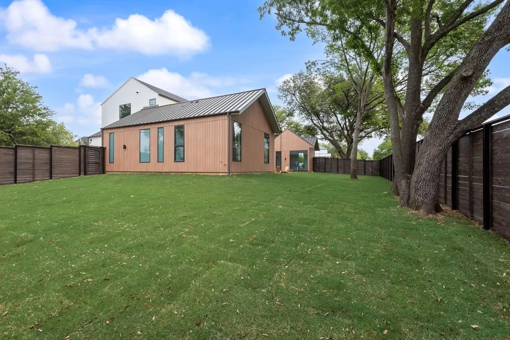 Back lawn with the house and a wood fence