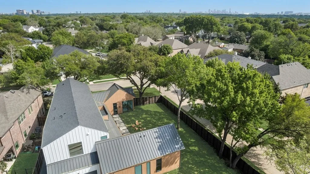 Aerial view of the house and yard, with a city skyline on the horizon